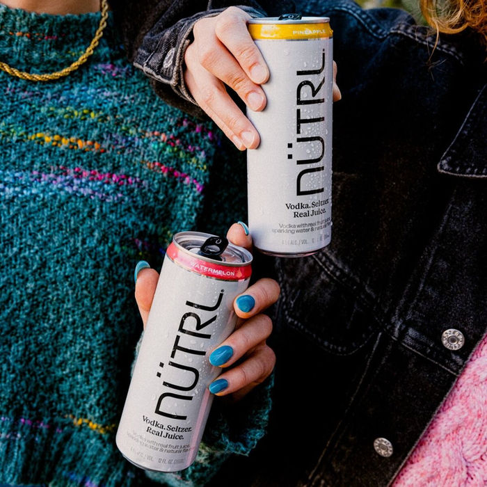Two people holding Nutrl Cans